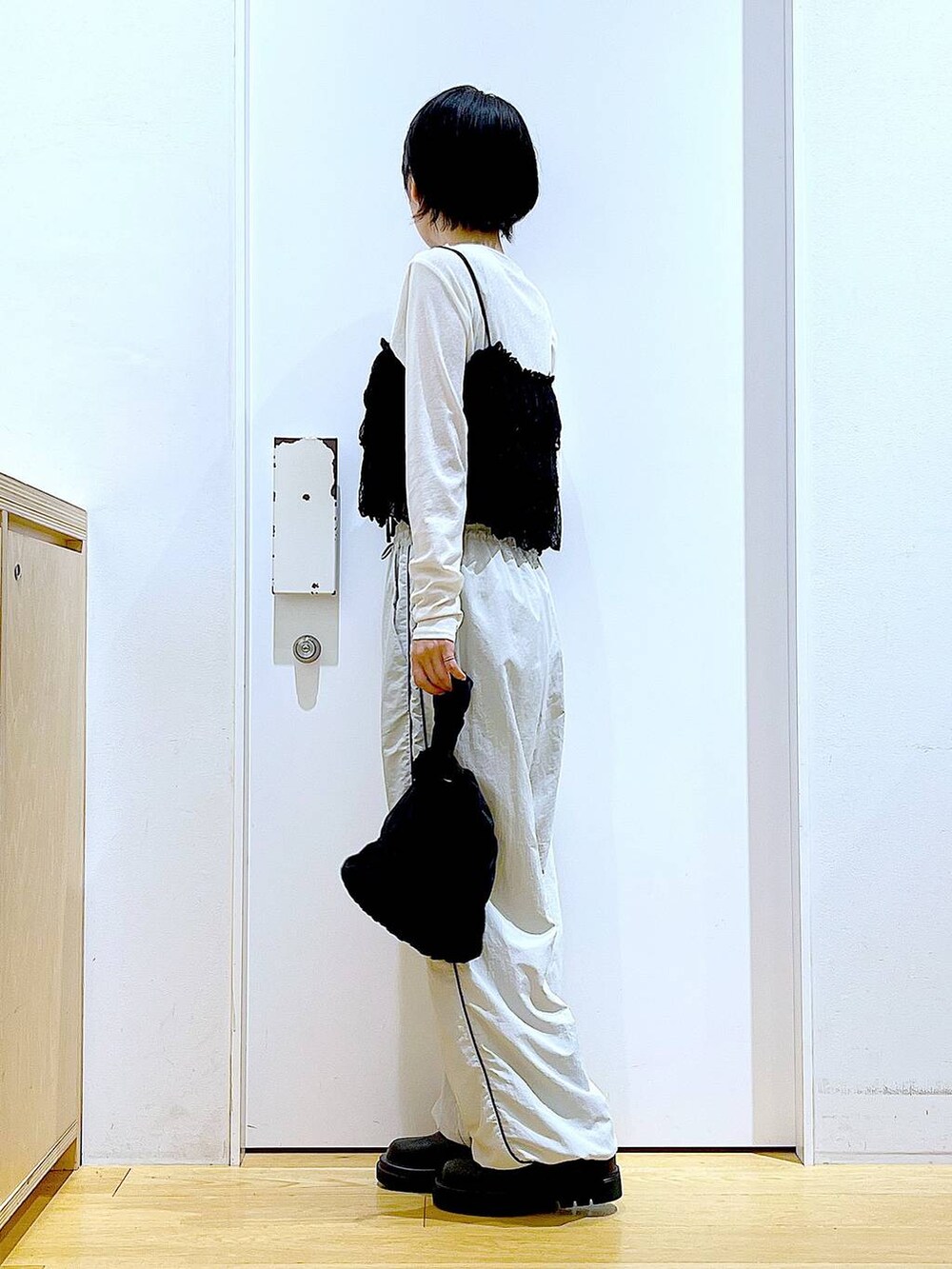 ブラック系のブーツ、ブラック系のショルダーバッグ、ホワイト系のTシャツ/カットソーを着用したレディースの秋コーディネートの3枚目の写真