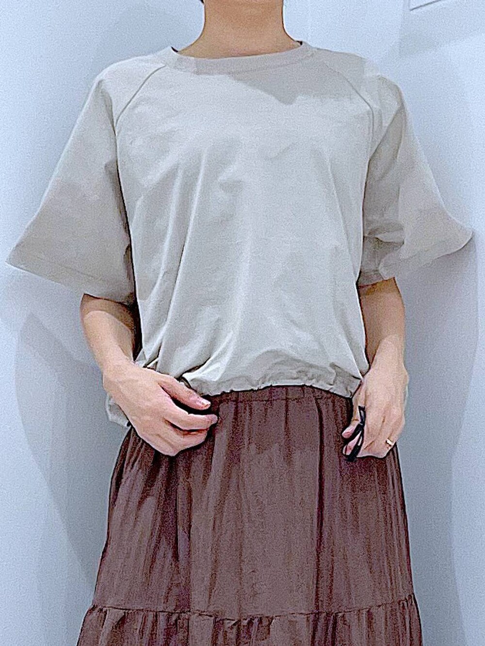 ブラック系のショルダーバッグ、ホワイト系のサンダル、ベージュ系のTシャツ/カットソーを着用したレディースの夏コーディネートの7枚目の写真