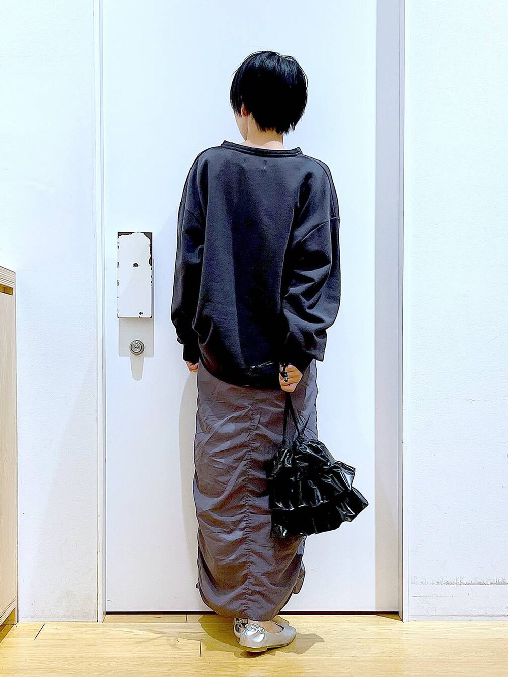 グレー系のスカート、ブラック系のショルダーバッグ、シルバー系のパンプスを着用したレディースの春コーディネートの5枚目の写真