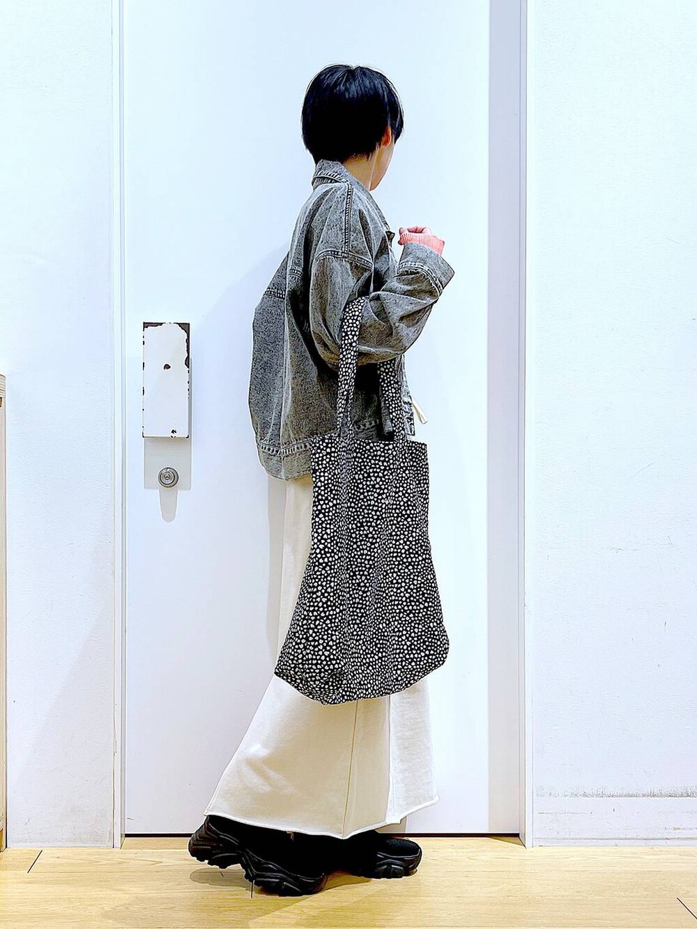 ブラック系のブーツ、その他のトートバッグ、ブラック系のデニムジャケットを着用したレディースの春コーディネートの4枚目の写真