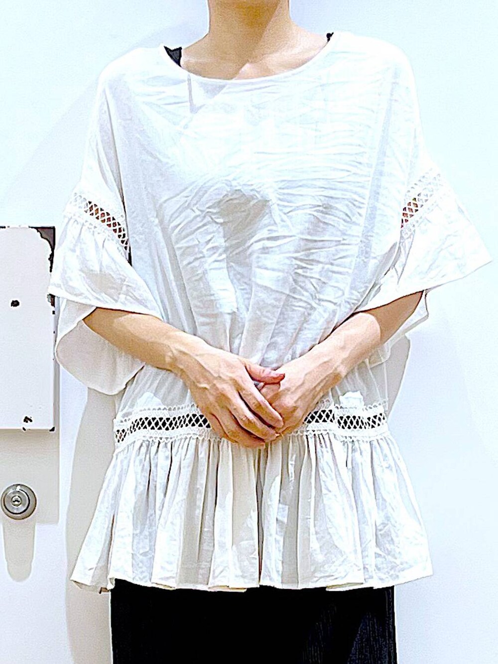 ホワイト系のチュニック、ブラック系のその他パンツ、ブラック系のパンプスを着用したレディースの夏コーディネートの7枚目の写真