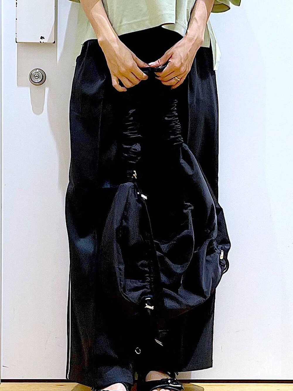 ブラック系のサンダル、ブラック系のショルダーバッグ、ブラック系のスラックスを着用したレディースの夏コーディネートの9枚目の写真