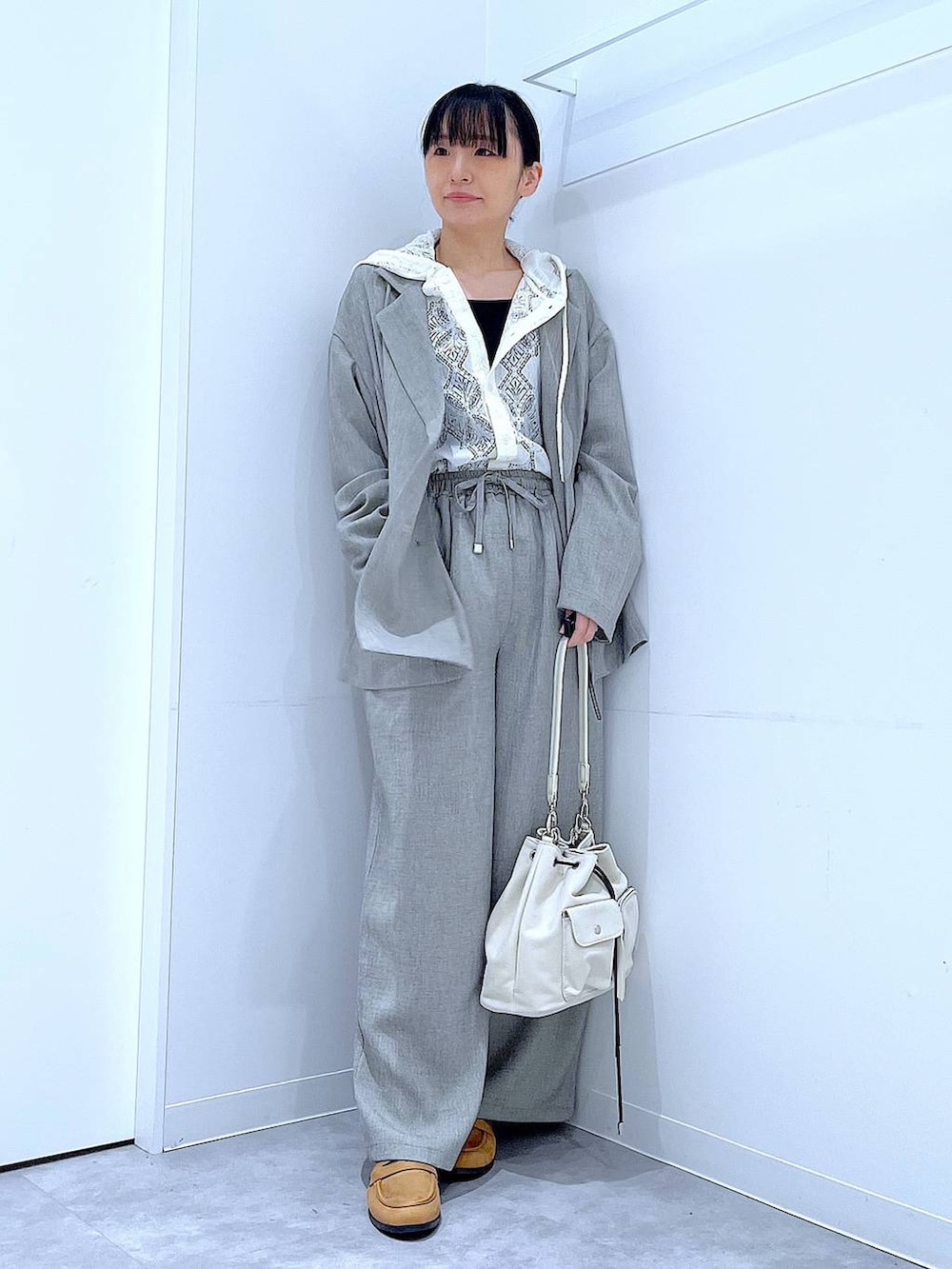 ホワイト系のショルダーバッグ、ベージュ系のローファー、ホワイト系のシャツ/ブラウスを着用したレディースの春コーディネートの2枚目の写真