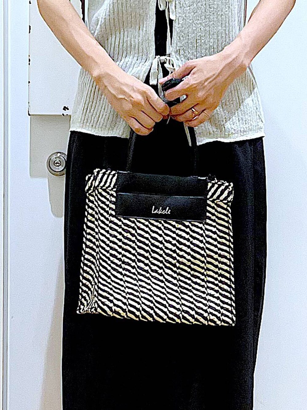 ブラック系のキャミソール、ブラック系のショルダーバッグ、ブラック系のサンダルを着用したレディースの夏コーディネートの9枚目の写真