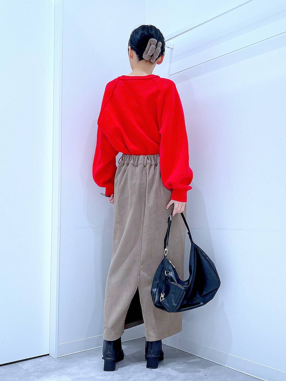 レッド系のニット/セーター、ブラック系のブーツ、ブラック系のショルダーバッグを着用したレディースの冬コーディネートの5枚目の写真