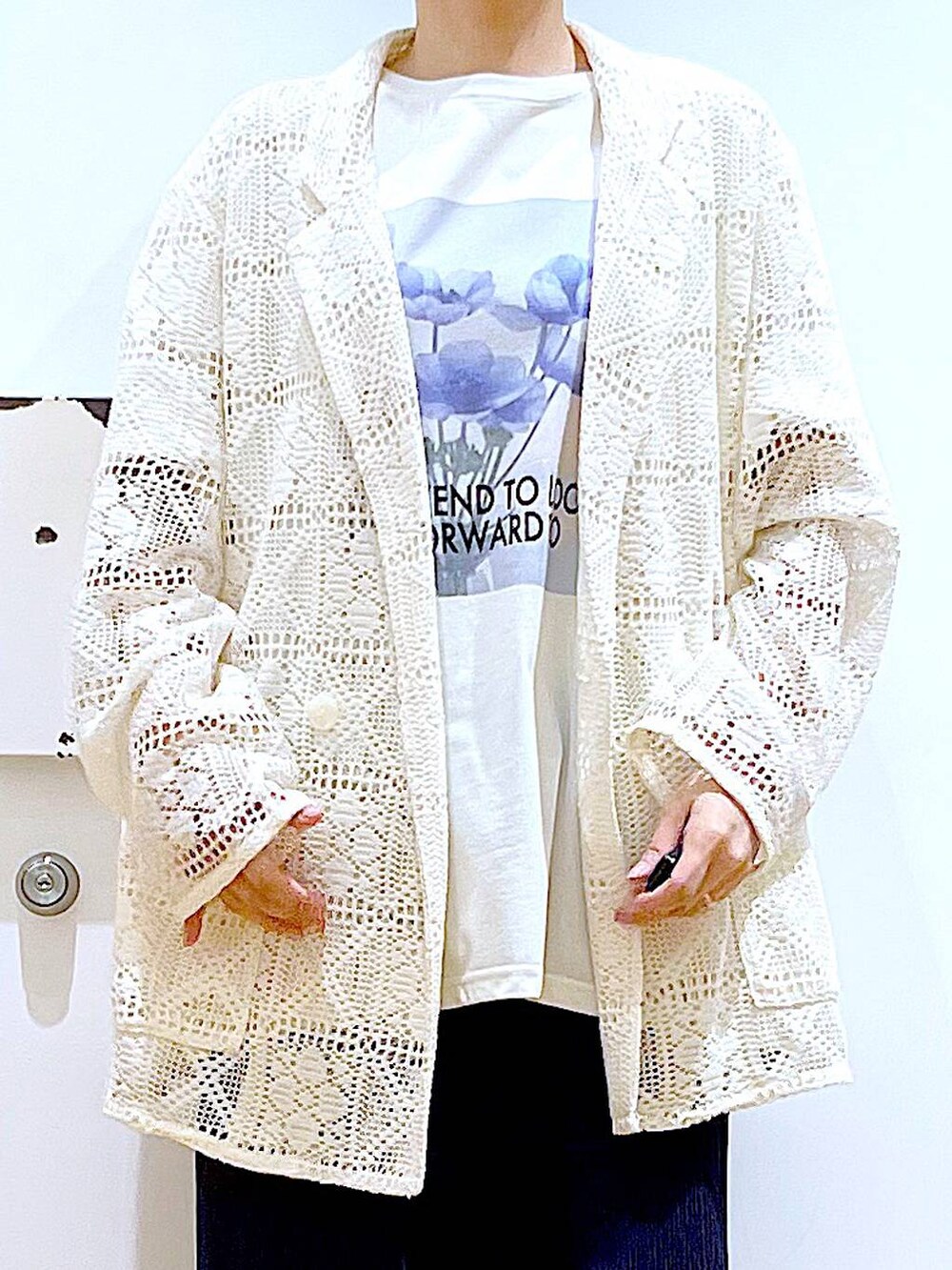 ブラック系のパンプス、ブラック系のショルダーバッグ、ホワイト系のテーラードジャケットを着用したレディースの春コーディネートの7枚目の写真