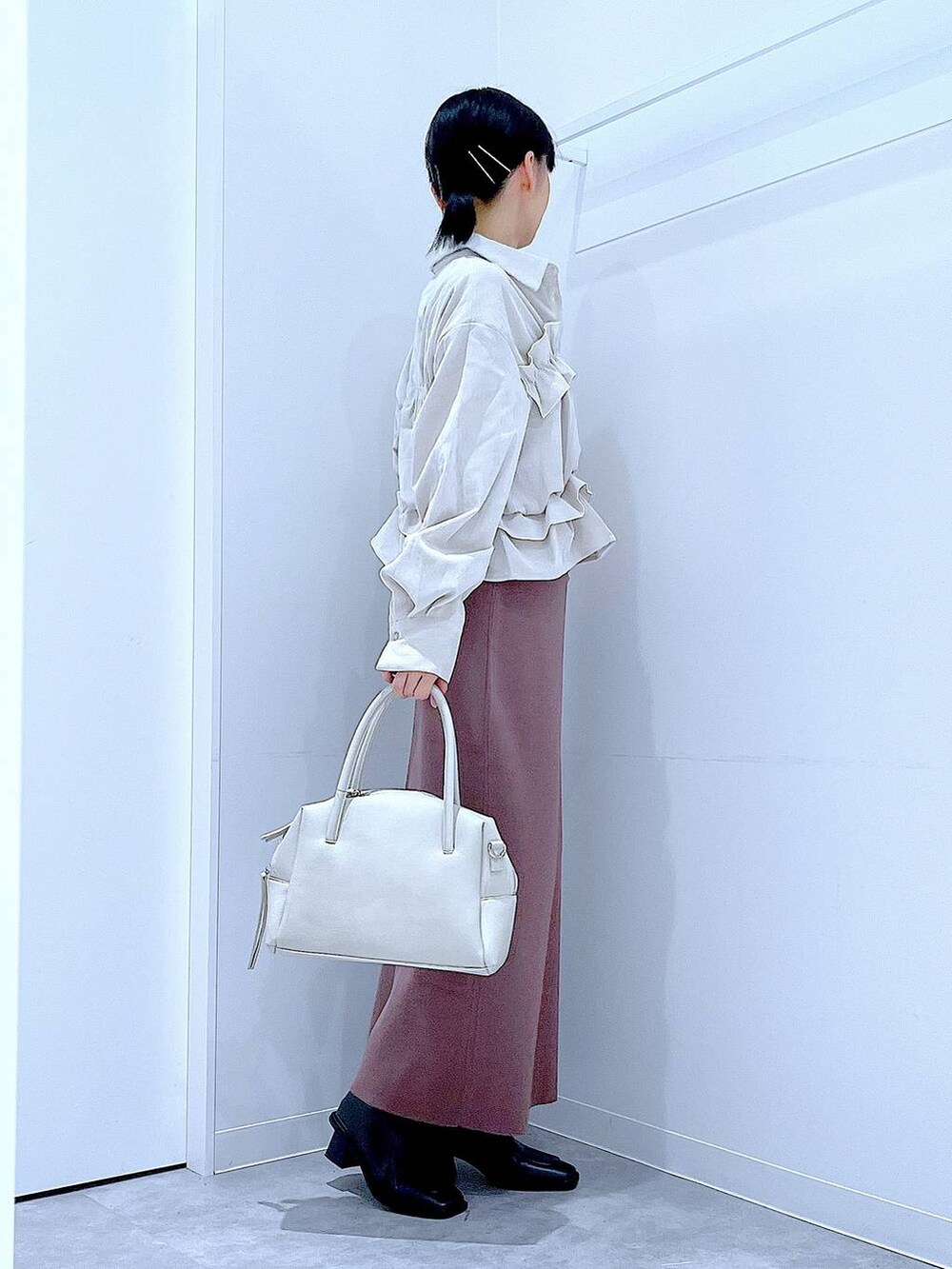 グレー系のボストンバッグ、ブラック系のブーツ、ベージュ系のシャツ/ブラウスを着用したレディースの秋コーディネートの4枚目の写真