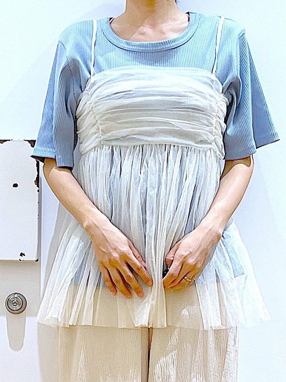 ホワイト系のキャミソール、シルバー系のサンダル、ブルー系のハンドバッグを着用したレディースの夏コーディネートの7枚目の写真