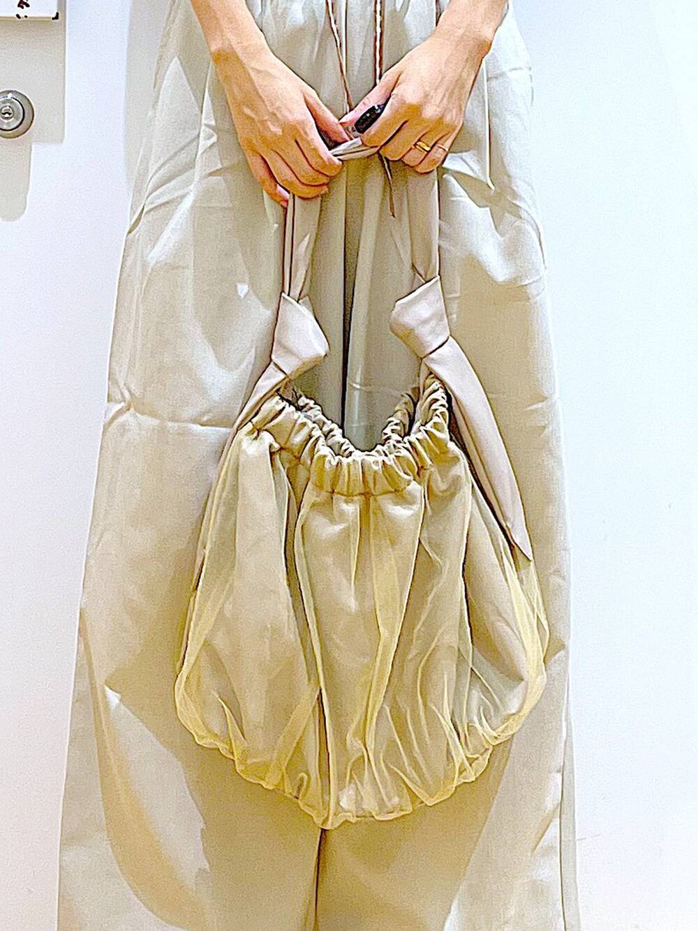 ベージュ系のトートバッグ、ホワイト系のパンプス、ブラック系のTシャツ/カットソーを着用したレディースの秋コーディネートの9枚目の写真