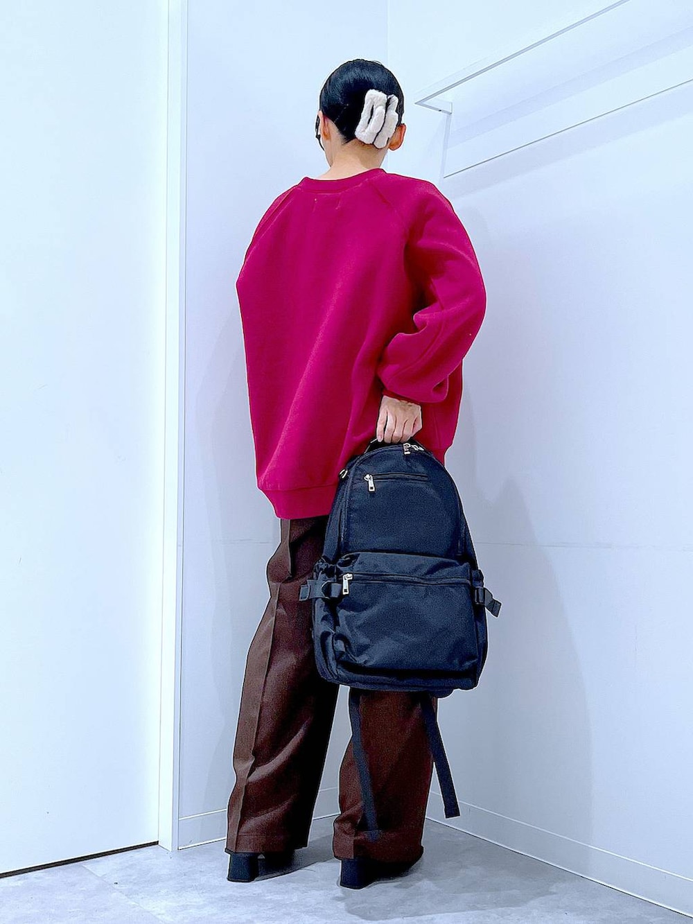 ブラック系のブーツ、ブラウン系のスラックス、ブラック系のバックパック/リュックを着用したレディースの冬コーディネートの5枚目の写真