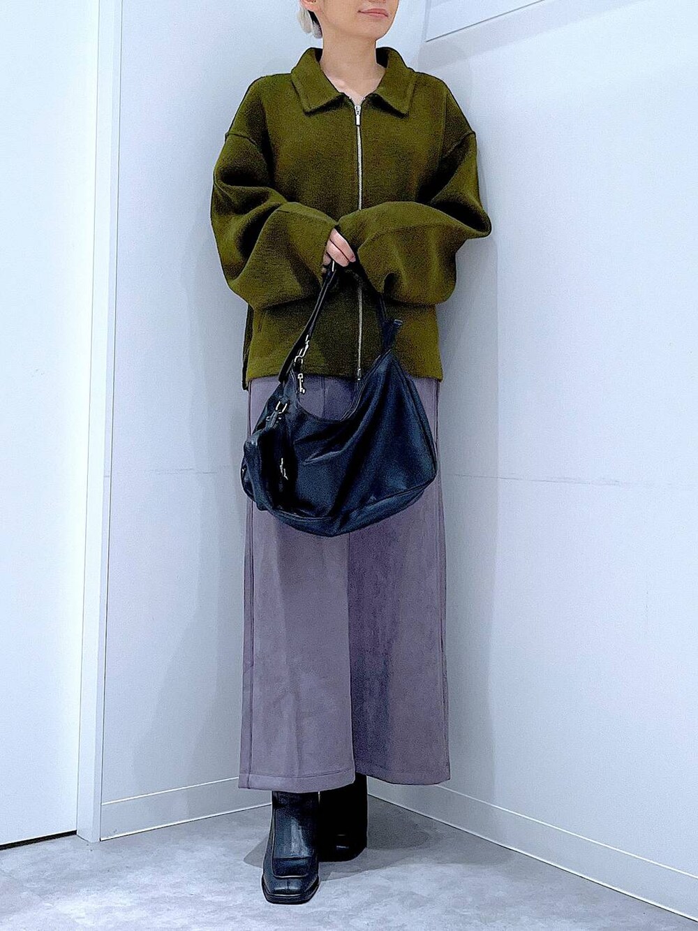 グリーン系のブルゾン、ブラック系のブーツ、ブラック系のショルダーバッグを着用したレディースの秋コーディネートの6枚目の写真