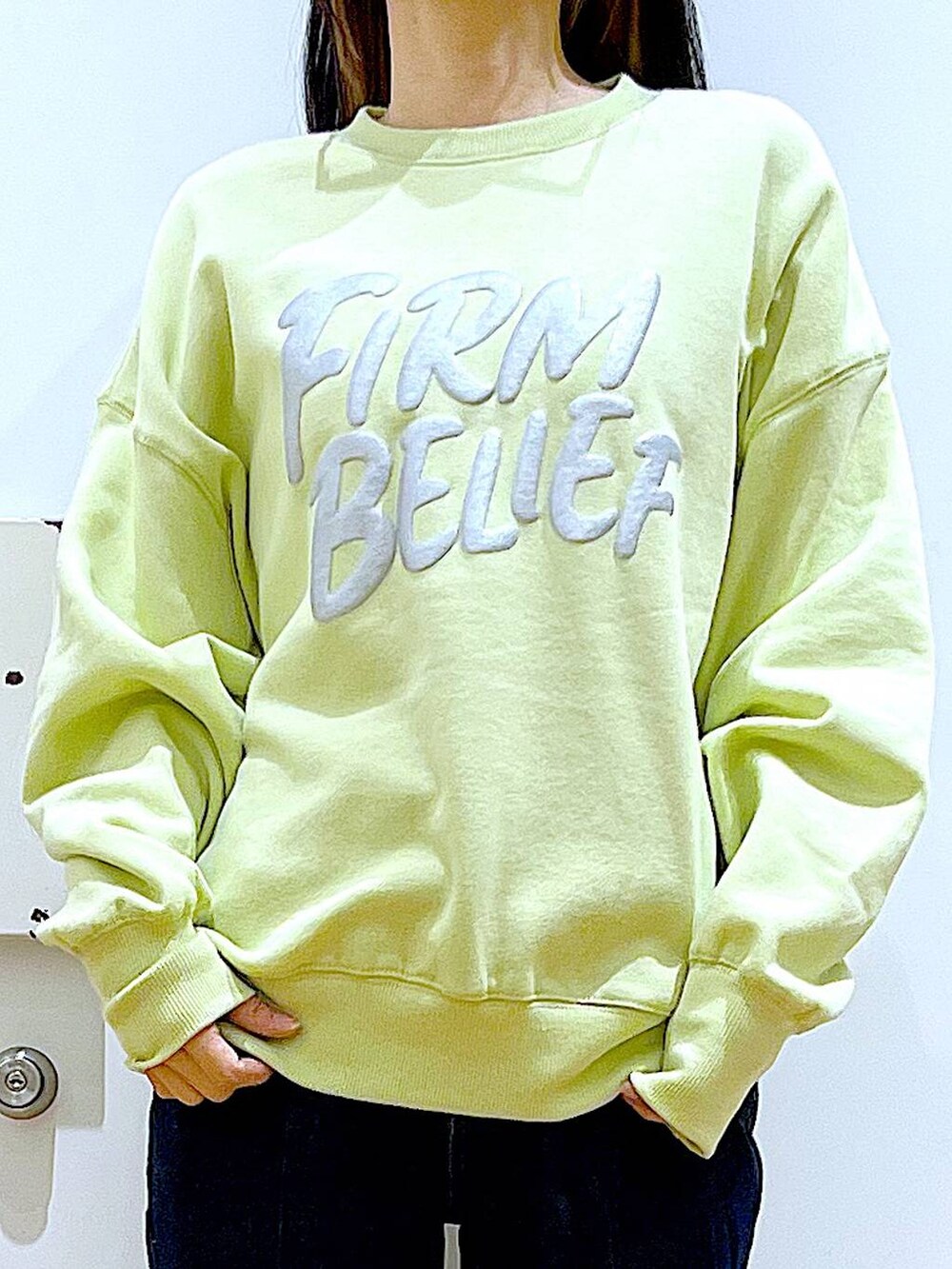 ブルー系のデニムパンツ、イエロー系のスウェット、ベージュ系のブーツを着用したレディースの冬コーディネートの7枚目の写真