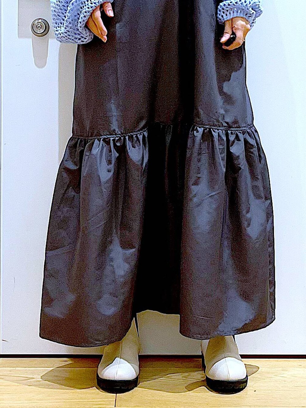 ブラック系のTシャツ/カットソー、ブルー系のニット/セーター、シルバー系のトートバッグを着用したレディースの春コーディネートの8枚目の写真