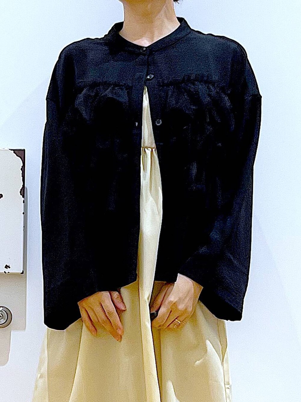 イエロー系のワンピース、ブラック系のショルダーバッグ、ブラック系のパンプスを着用したレディースの秋コーディネートの7枚目の写真