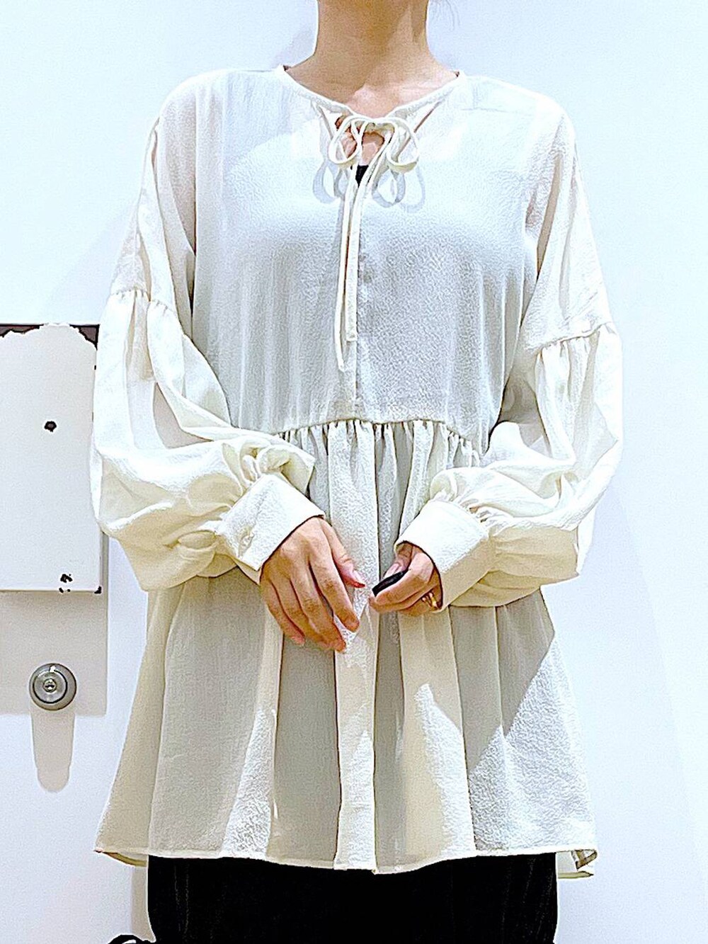 ホワイト系のパンプス、ブラック系のその他パンツ、ホワイト系のチュニックを着用したレディースの秋コーディネートの7枚目の写真