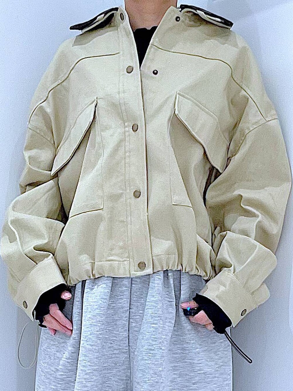 ブラック系のサンダル、ブラック系のショルダーバッグ、ベージュ系のブルゾンを着用したレディースの春コーディネートの7枚目の写真