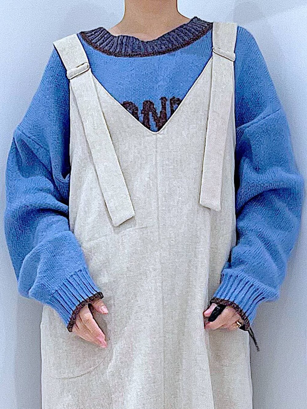 ブラック系のブーツ、ブラック系のハンドバッグ、ブルー系のニット/セーターを着用したレディースの秋コーディネートの7枚目の写真