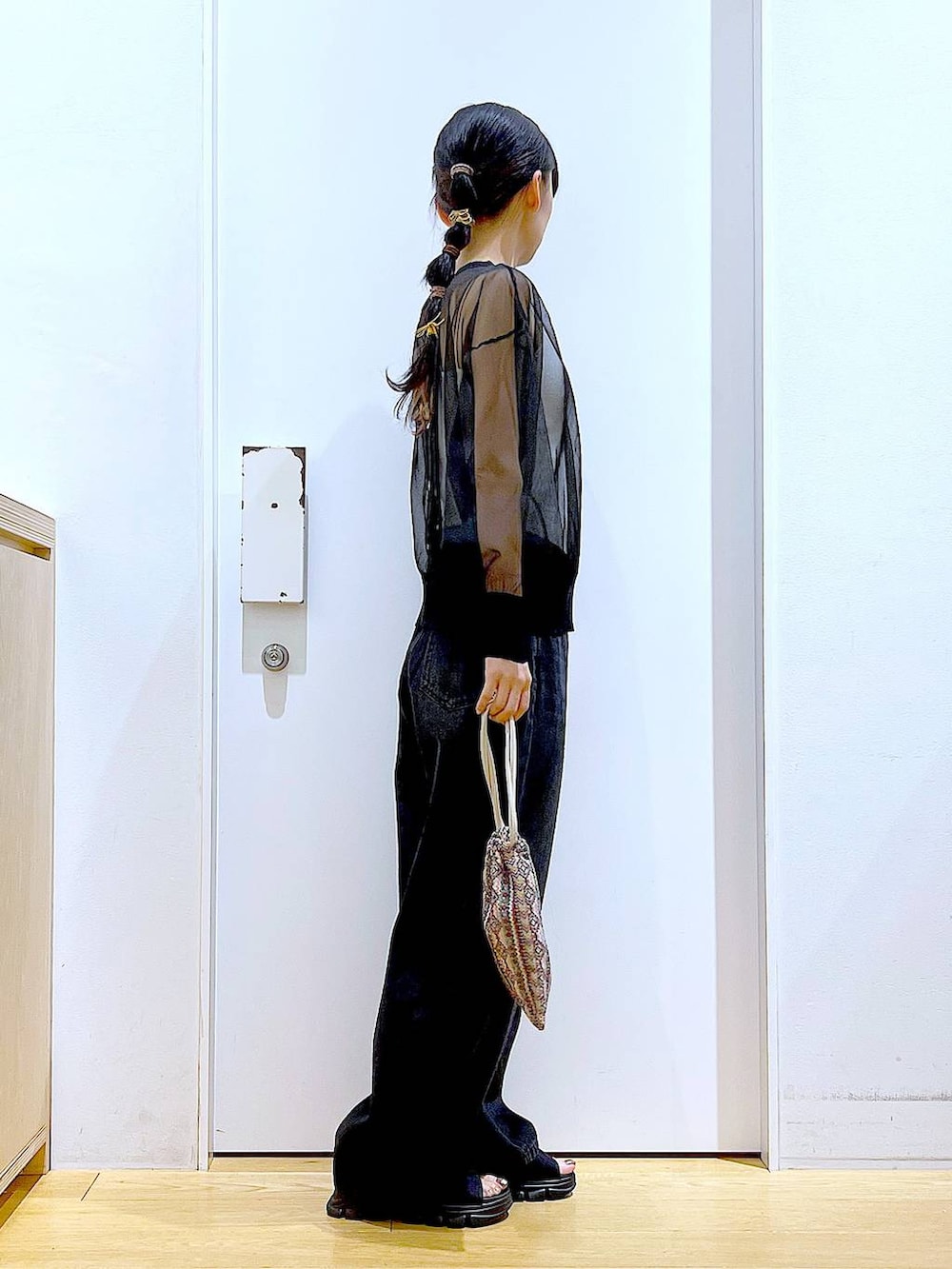 ピンク系のショルダーバッグ、ブラック系のサンダル、ブラック系のデニムパンツを着用したレディースの夏コーディネートの4枚目の写真