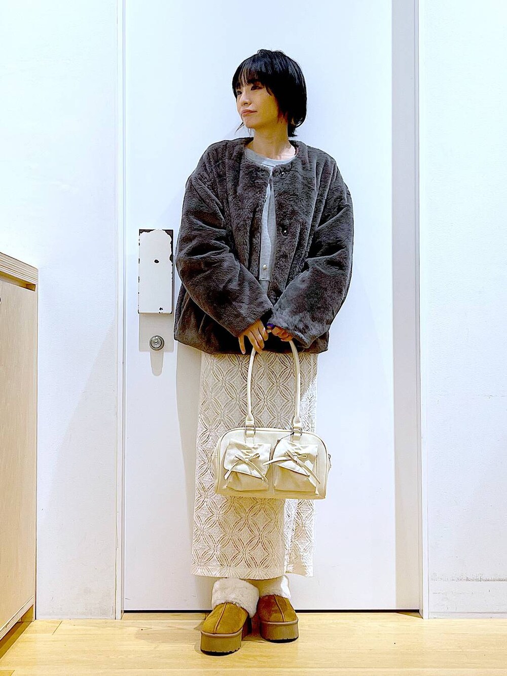 ベージュ系のスリッポン、ホワイト系のハンドバッグ、グレー系のスウェットを着用したレディースの秋コーディネートの2枚目の写真