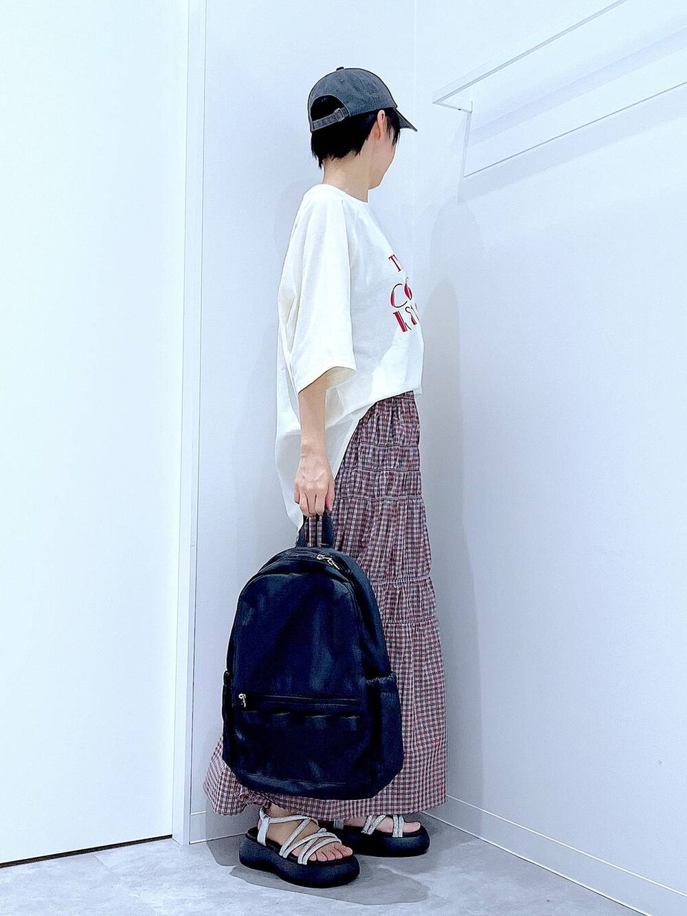 ブラック系のバックパック/リュック、シルバー系のサンダル、ホワイト系のTシャツ/カットソーを着用したレディースの夏コーディネートの4枚目の写真