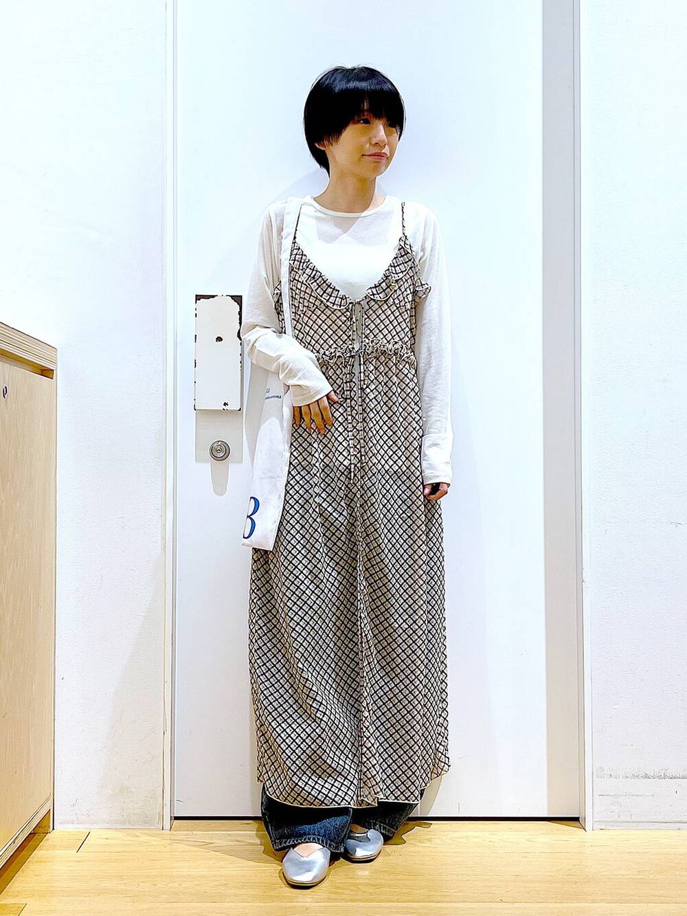 ブルー系のデニムパンツ、シルバー系のパンプス、ホワイト系のTシャツ/カットソーを着用したレディースの春コーディネートの2枚目の写真