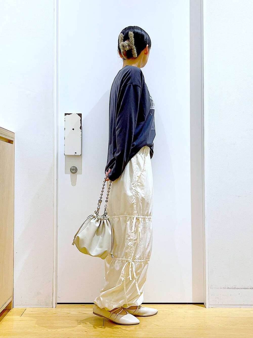 ベージュ系のショルダーバッグ、ホワイト系のパンプス、ホワイト系のその他パンツを着用したレディースの秋コーディネートの4枚目の写真