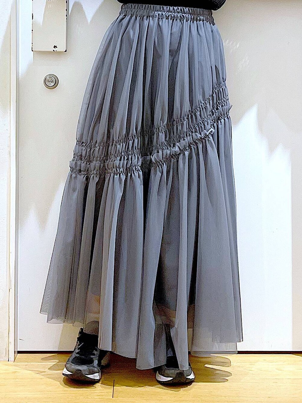 ブラック系のTシャツ/カットソー、グレー系のスカートを着用したレディースの春コーディネートの8枚目の写真