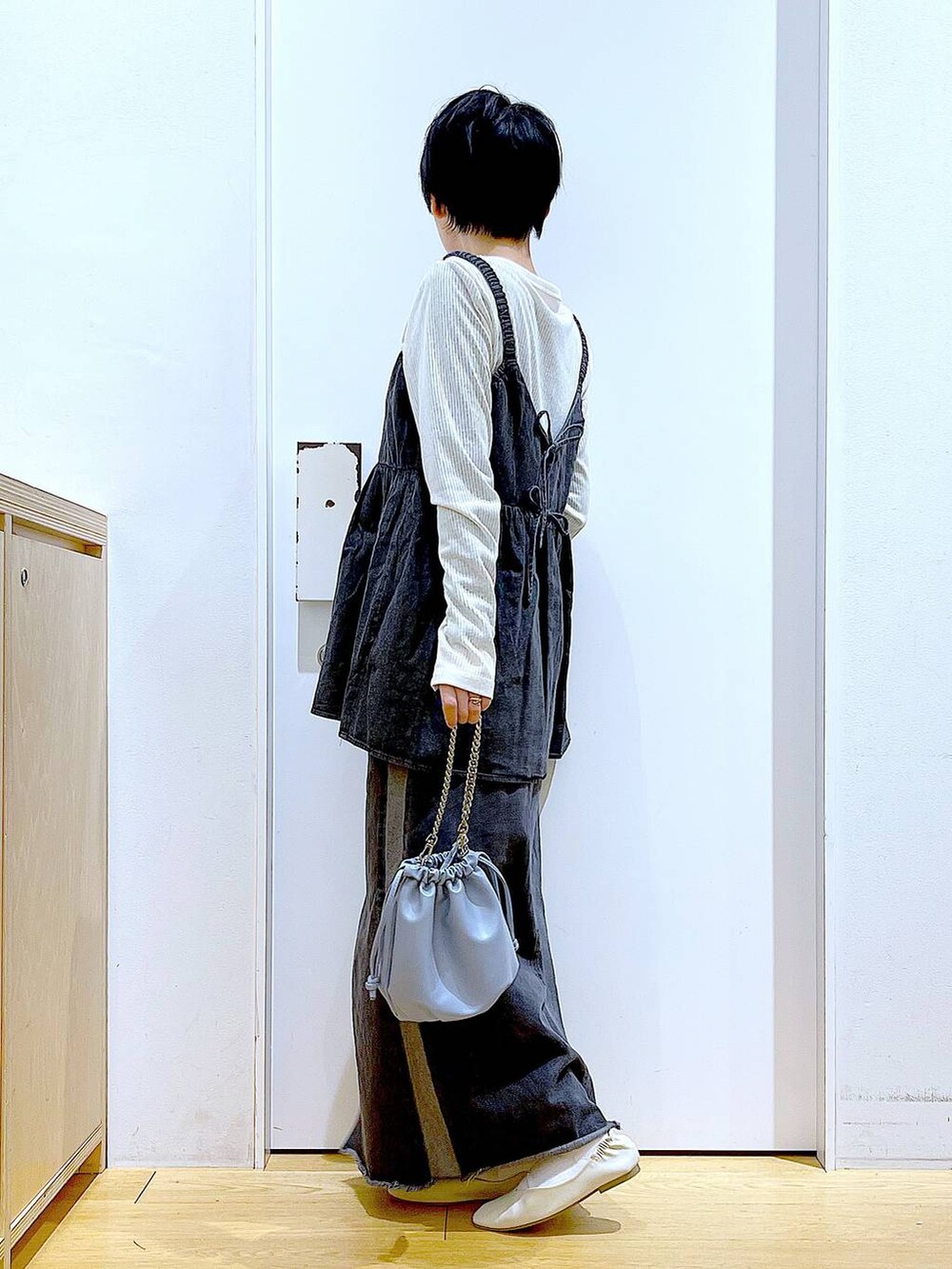 ブルー系のショルダーバッグ、ホワイト系のパンプス、ブラック系のデニムスカートを着用したレディースの春コーディネートの3枚目の写真