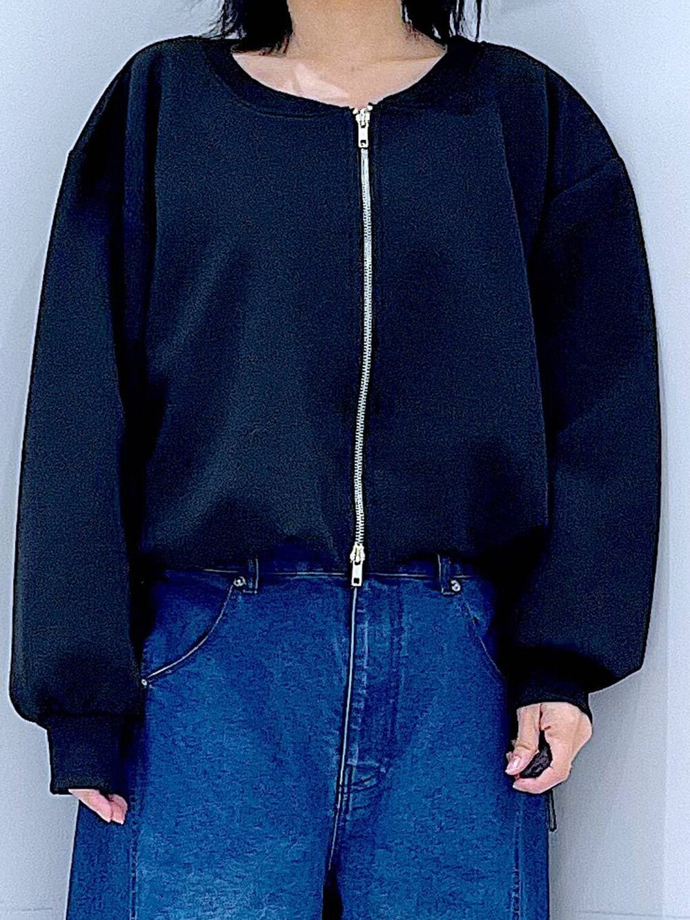 ブラック系のショルダーバッグ、ブルー系のデニムパンツ、ブラック系のスウェットを着用したレディースの春コーディネートの7枚目の写真