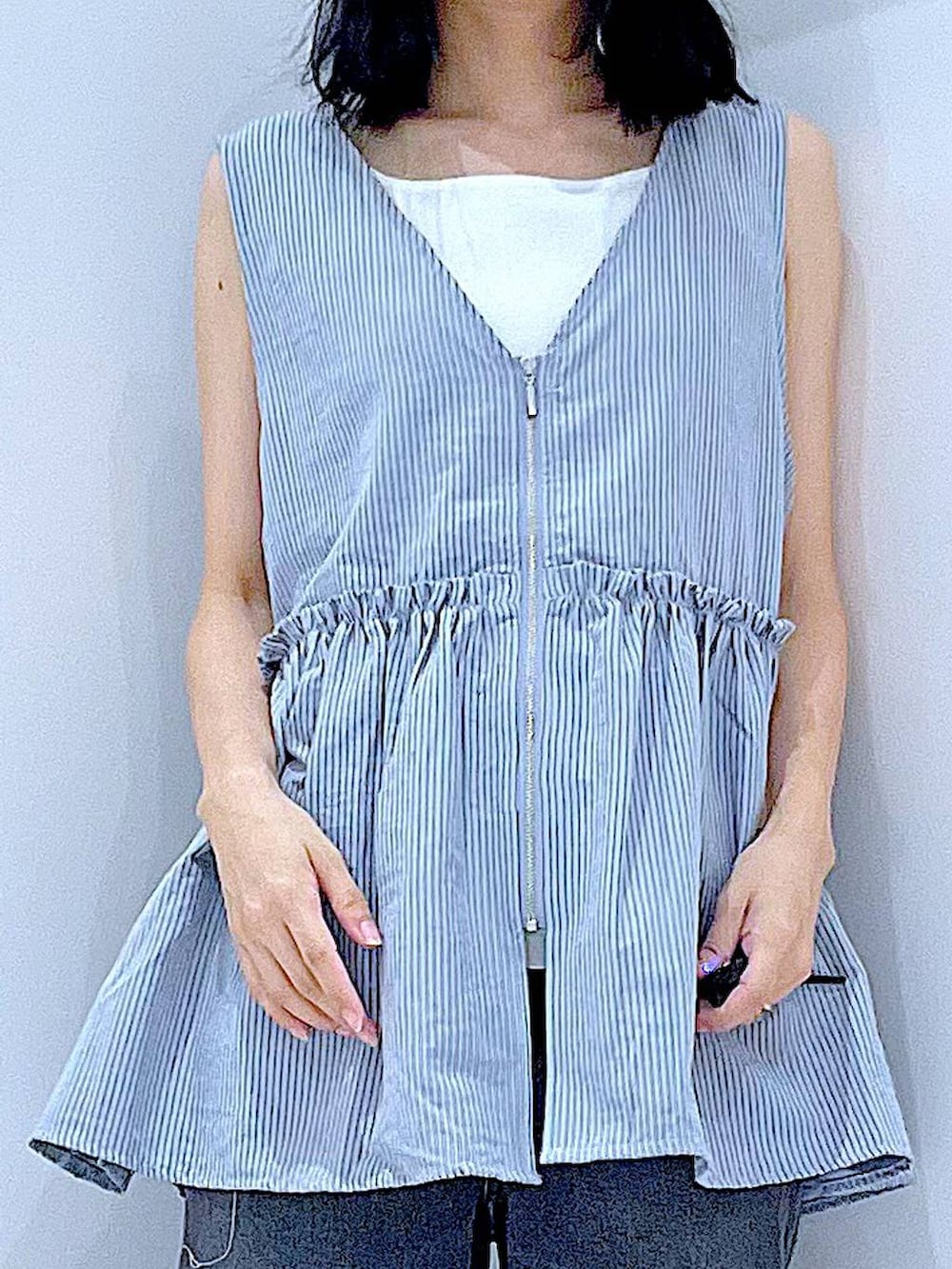 ブラック系のデニムパンツ、ブルー系のベスト、ホワイト系のタンクトップを着用したレディースの夏コーディネートの7枚目の写真