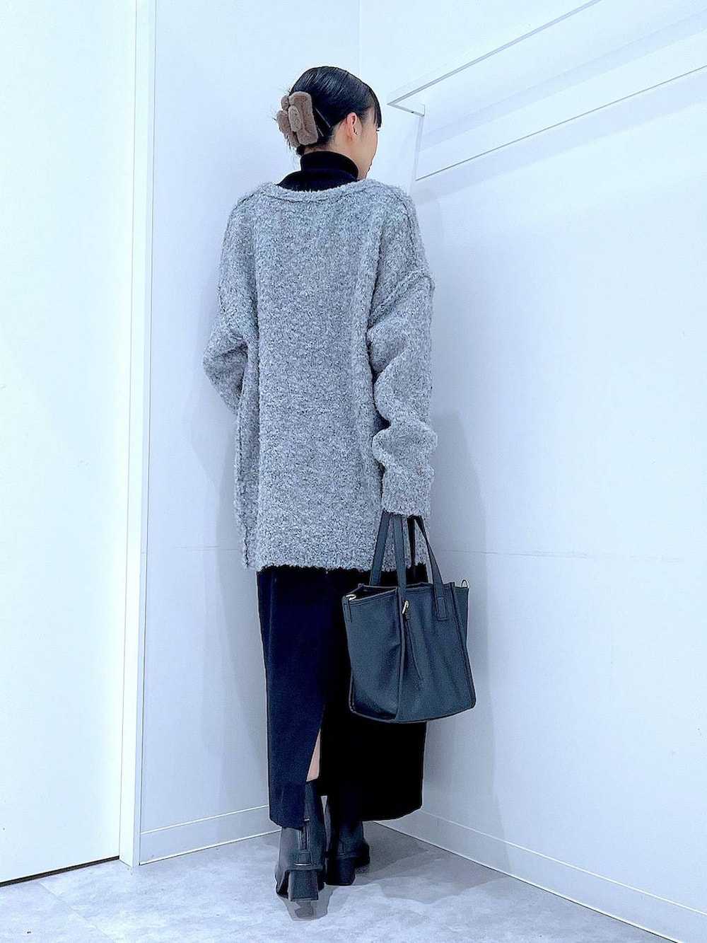 ブラック系のブーツ、グレー系のニット/セーター、ブラック系のスカートを着用したレディースの冬コーディネートの5枚目の写真