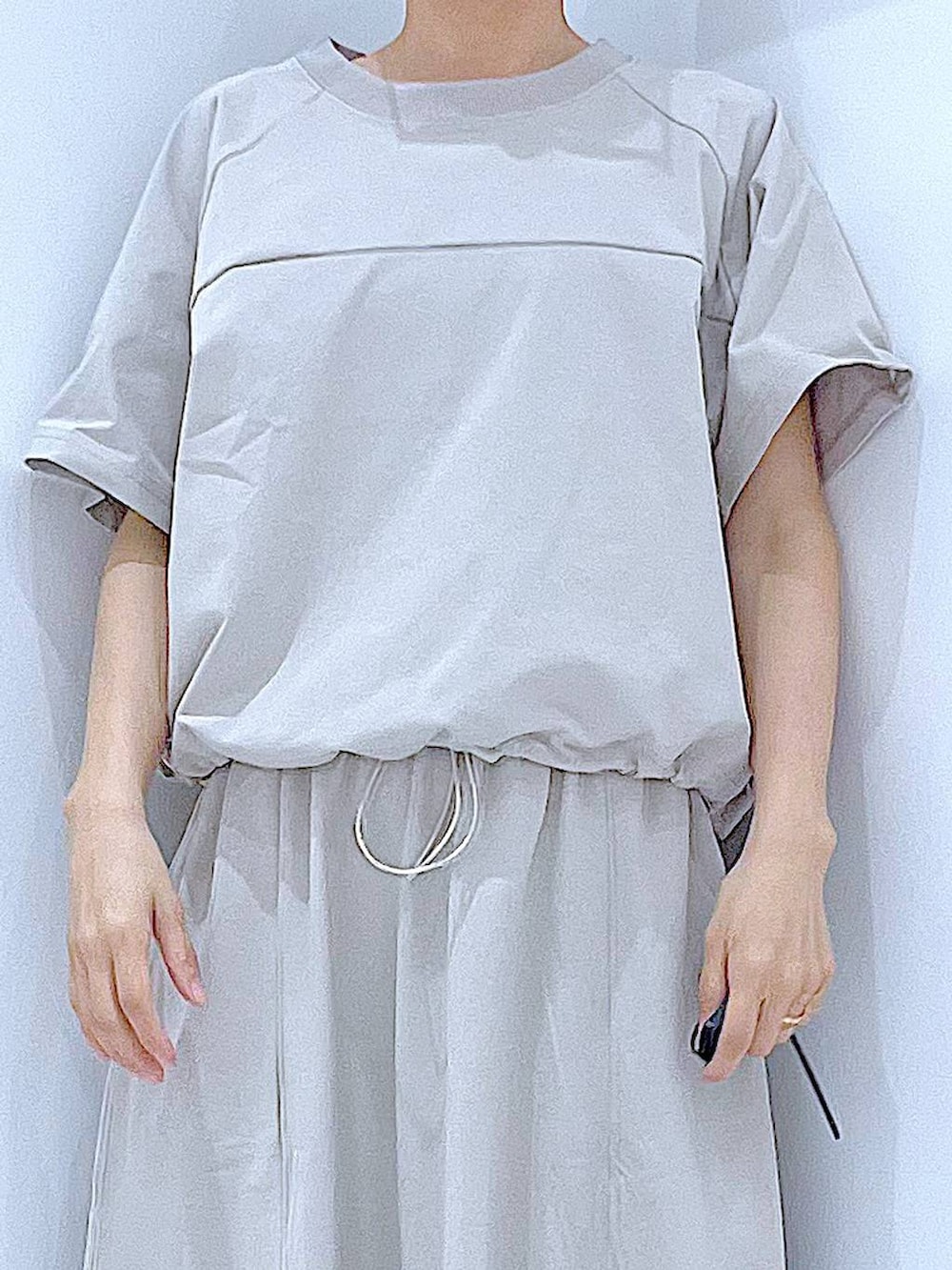 ブラック系のショルダーバッグ、ブラック系のサンダル、グレー系のTシャツ/カットソーを着用したレディースの夏コーディネートの7枚目の写真