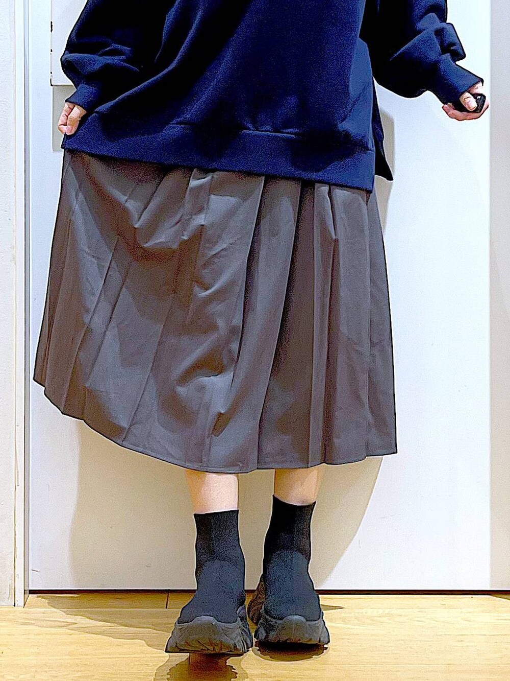 ブラック系のショルダーバッグ、ブラック系のブーツ、グレー系のスカートを着用したレディースの冬コーディネートの8枚目の写真