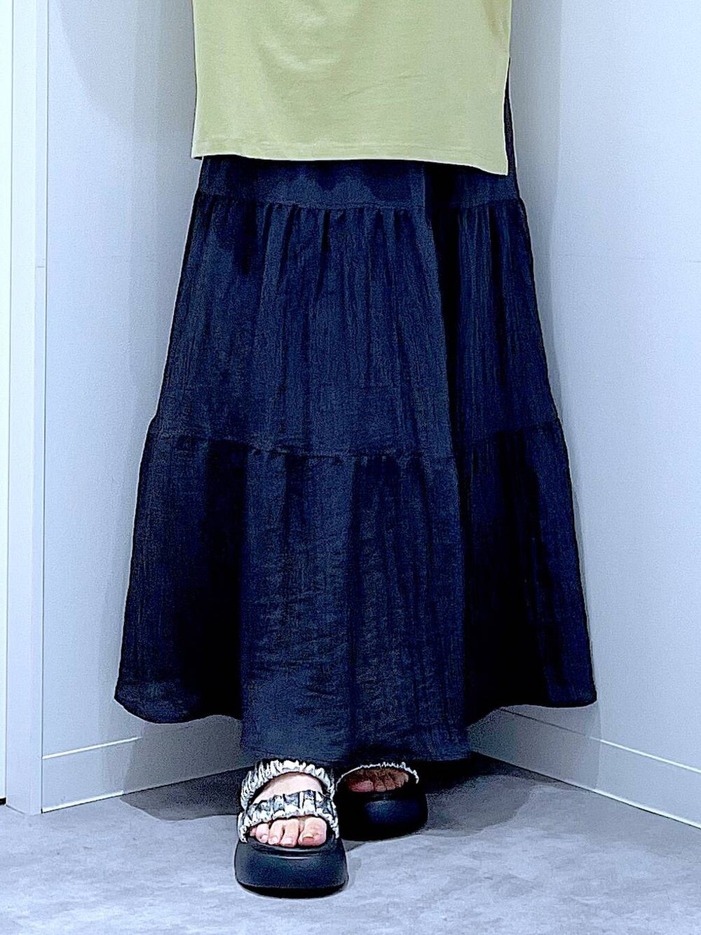 シルバー系のサンダル、グリーン系のTシャツ/カットソー、ブラック系のスカートを着用したレディースの夏コーディネートの8枚目の写真