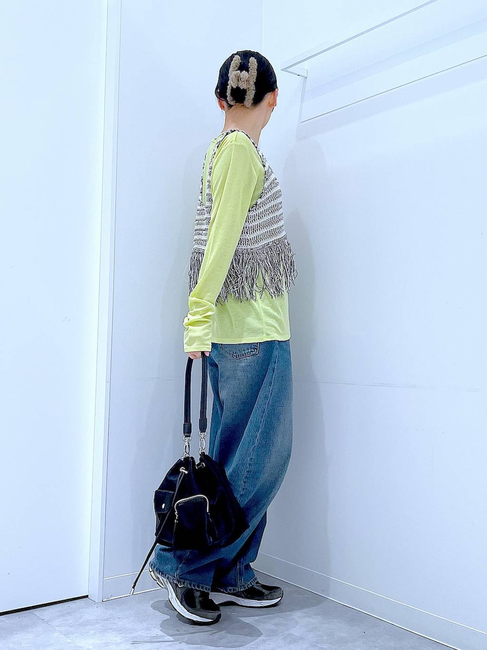 ブルー系のデニムパンツ、グリーン系のTシャツ/カットソー、ブラック系のショルダーバッグを着用したレディースの春コーディネートの4枚目の写真