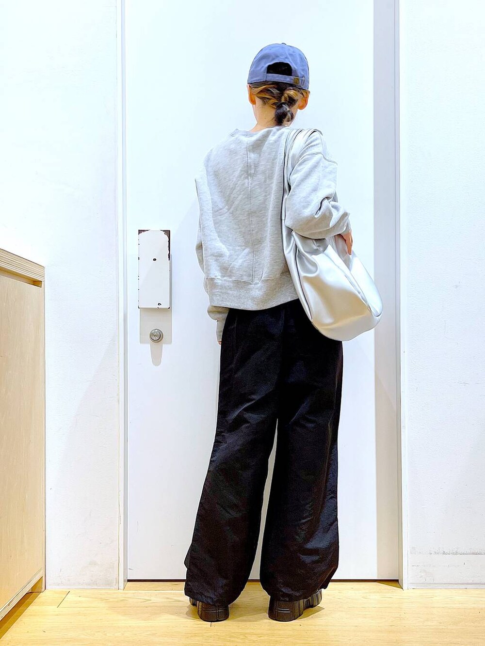 シルバー系のトートバッグ、ブラック系のブーツ、ブラック系のその他パンツを着用したレディースの冬コーディネートの5枚目の写真