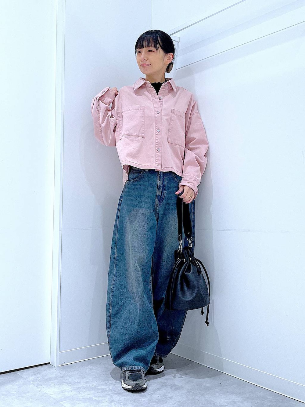 ブルー系のデニムパンツ、ピンク系のシャツ/ブラウス、ブラック系のショルダーバッグを着用したレディースの冬コーディネートの2枚目の写真