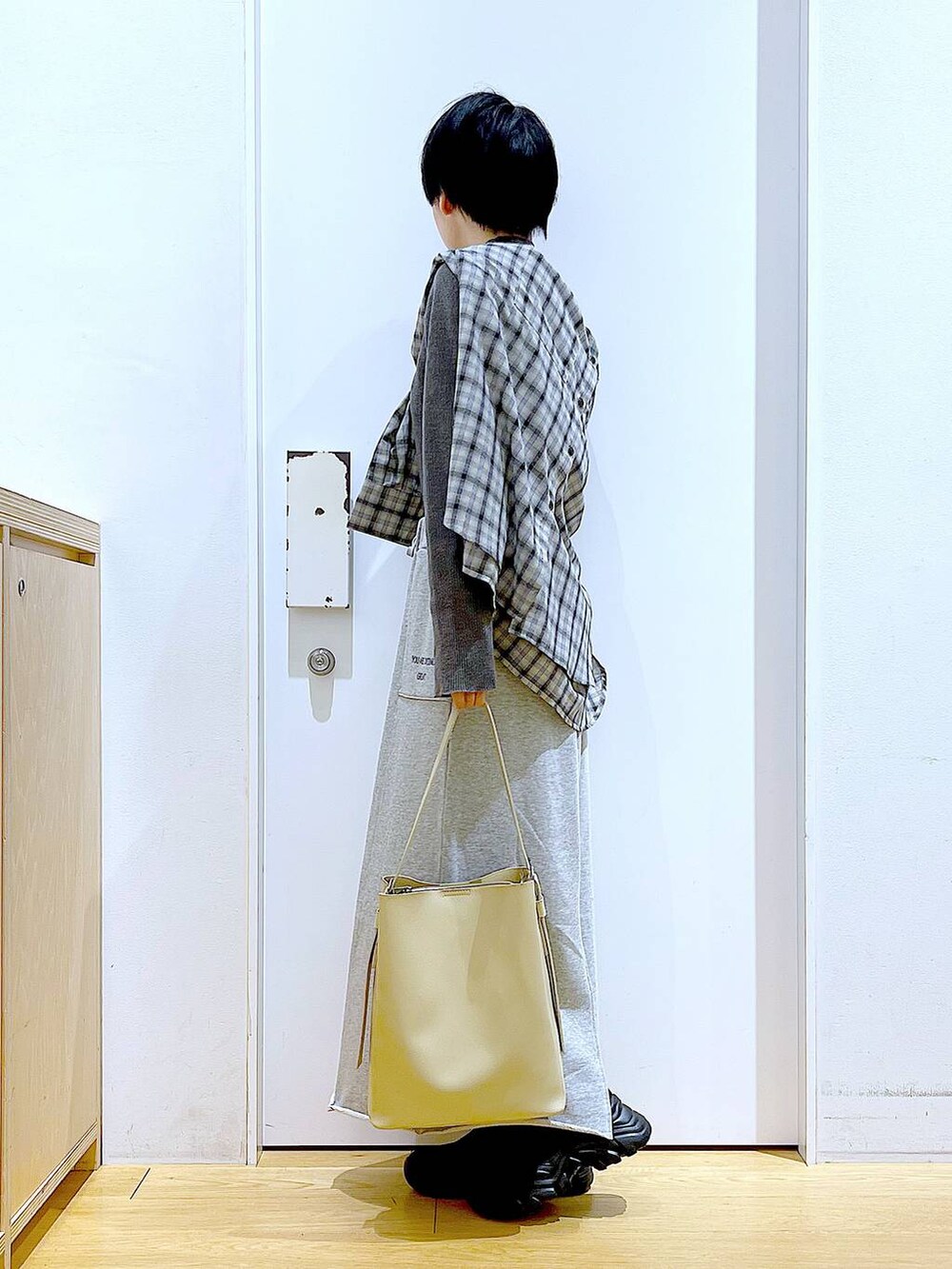 ブラック系のブーツ、ホワイト系のショルダーバッグ、ベージュ系のシャツ/ブラウスを着用したレディースの春コーディネートの3枚目の写真