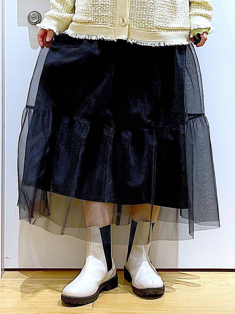 グレー系のショルダーバッグ、ベージュ系のブーツ、ブラック系のスカートを着用したレディースの冬コーディネートの8枚目の写真