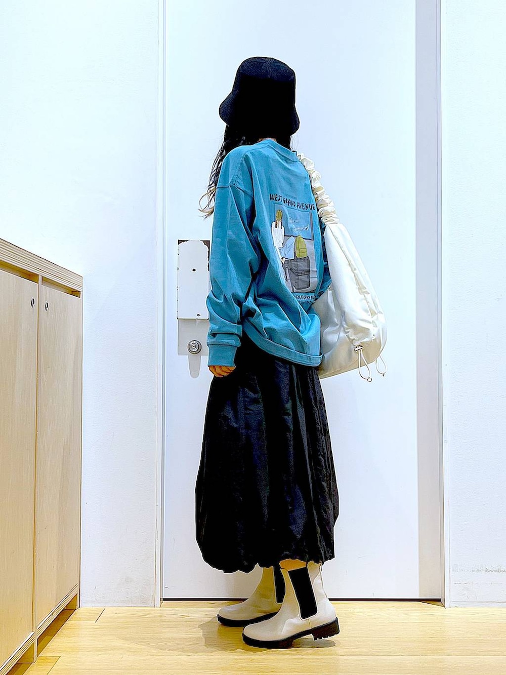 グリーン系のTシャツ/カットソー、ベージュ系のブーツ、ホワイト系のショルダーバッグを着用したレディースの春コーディネートの3枚目の写真