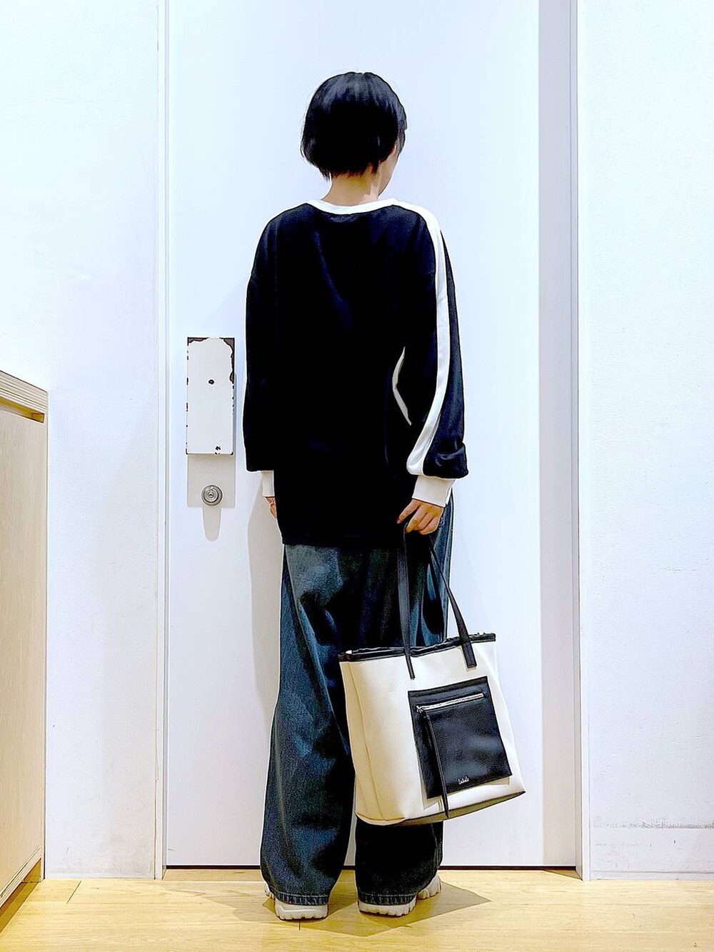 ベージュ系のブーツ、ホワイト系のトートバッグ、ブラック系のTシャツ/カットソーを着用したレディースの秋コーディネートの5枚目の写真