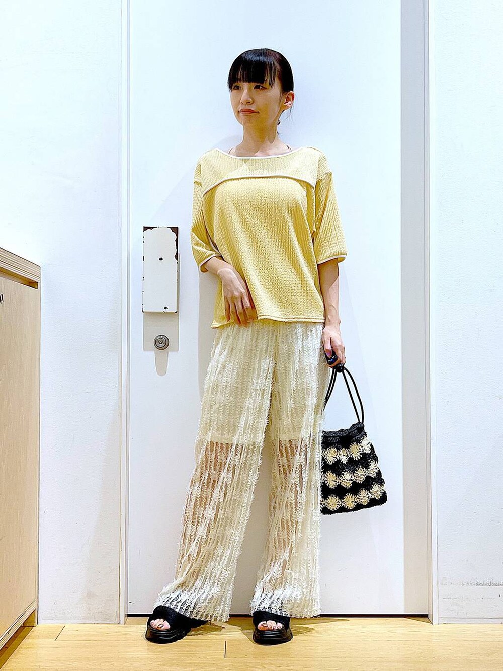 ブラック系のサンダル、ブラック系のショルダーバッグ、ホワイト系のその他パンツを着用したレディースの春コーディネートの2枚目の写真