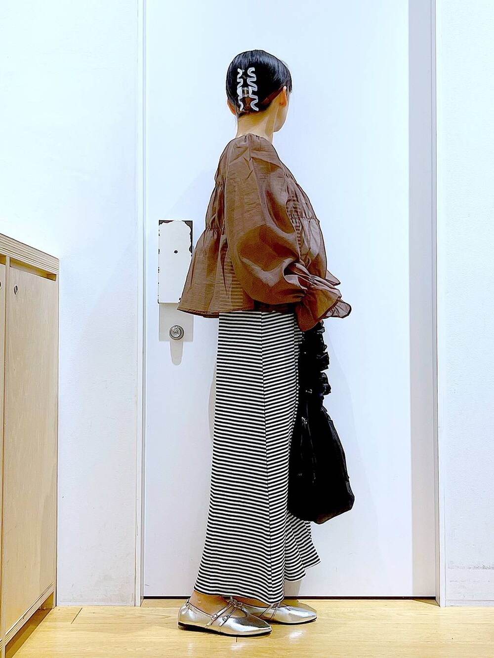 ブラック系のワンピース、シルバー系のパンプス、ブラック系のショルダーバッグを着用したレディースの夏コーディネートの4枚目の写真