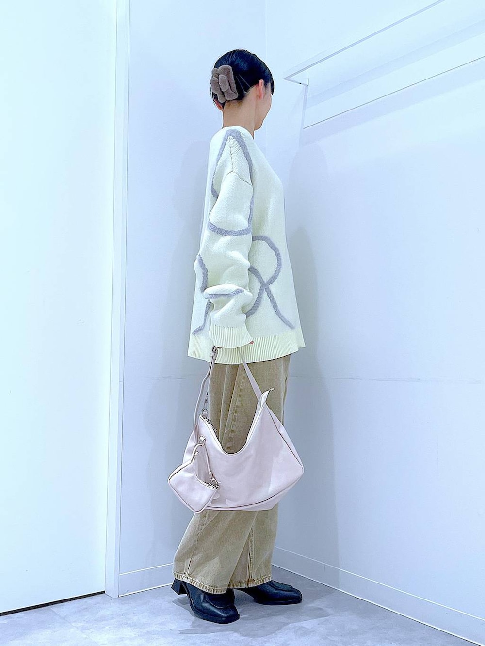 ベージュ系のデニムパンツ、ブラック系のブーツ、ホワイト系のショルダーバッグを着用したレディースの冬コーディネートの5枚目の写真