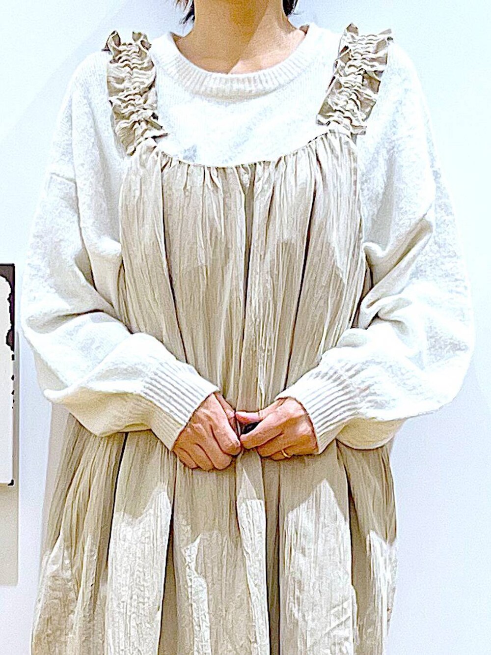 ブラック系のブーツ、ブラック系のトートバッグ、ベージュ系のニット/セーターを着用したレディースの冬コーディネートの7枚目の写真