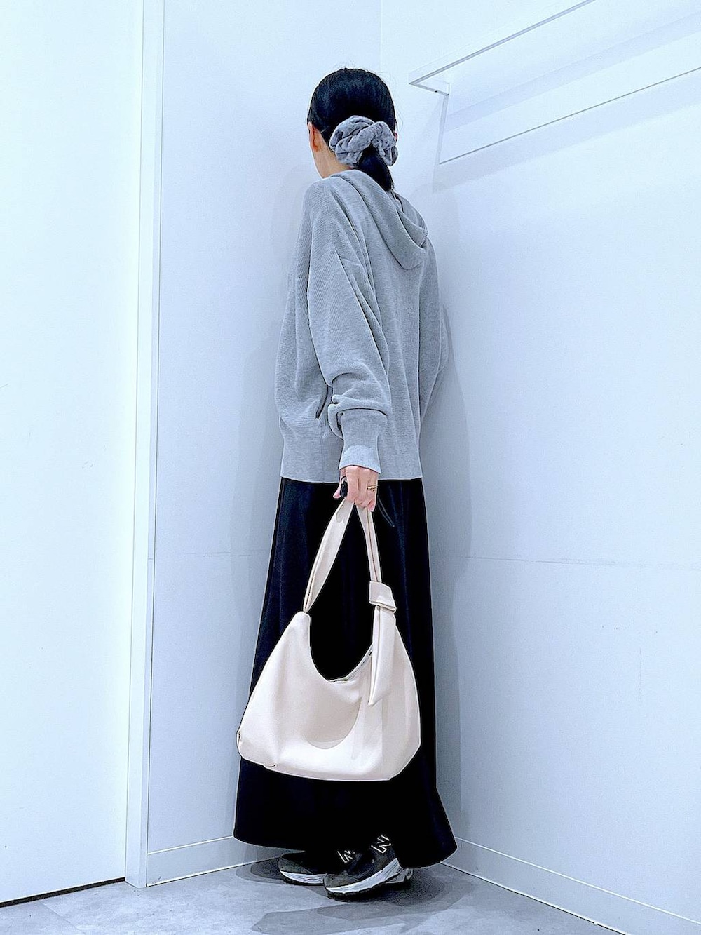 ホワイト系のショルダーバッグ、ブラック系のスカート、グレー系のカーディガン/ボレロを着用したレディースの春コーディネートの3枚目の写真