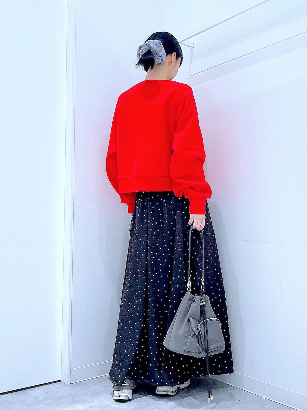 レッド系のスウェット、グレー系のシュシュを着用したレディースの春コーディネートの5枚目の写真