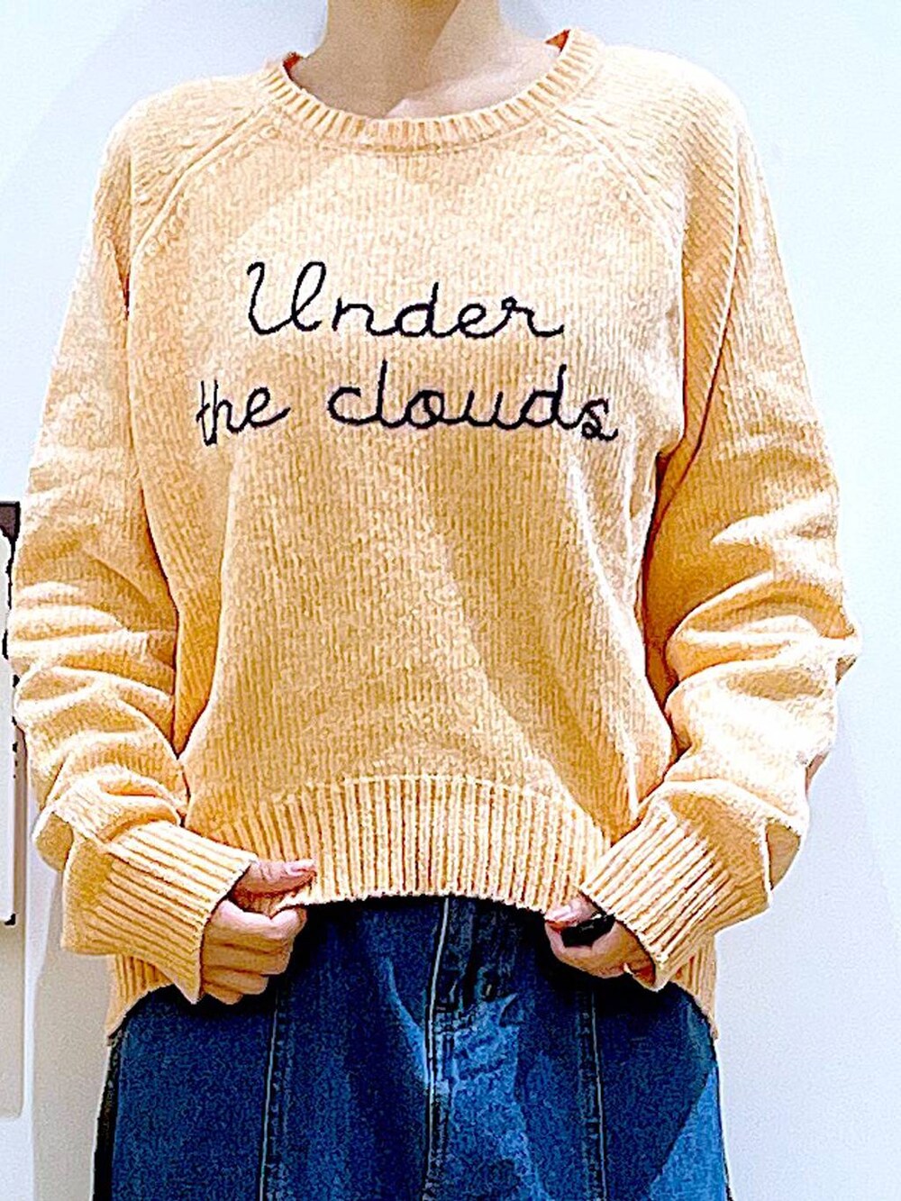 ブルー系のデニムスカート、ベージュ系のショルダーバッグ、ブラック系のブーツを着用したレディースの冬コーディネートの7枚目の写真