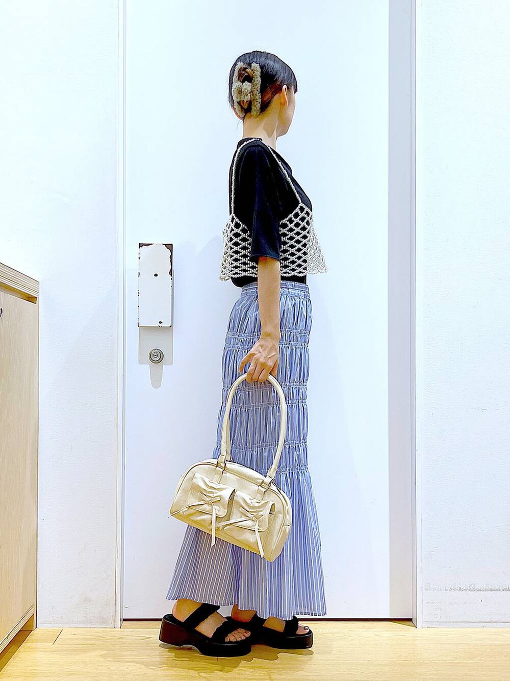 ブラック系のサンダル、ホワイト系のベスト、その他のスカートを着用したレディースの夏コーディネートの4枚目の写真