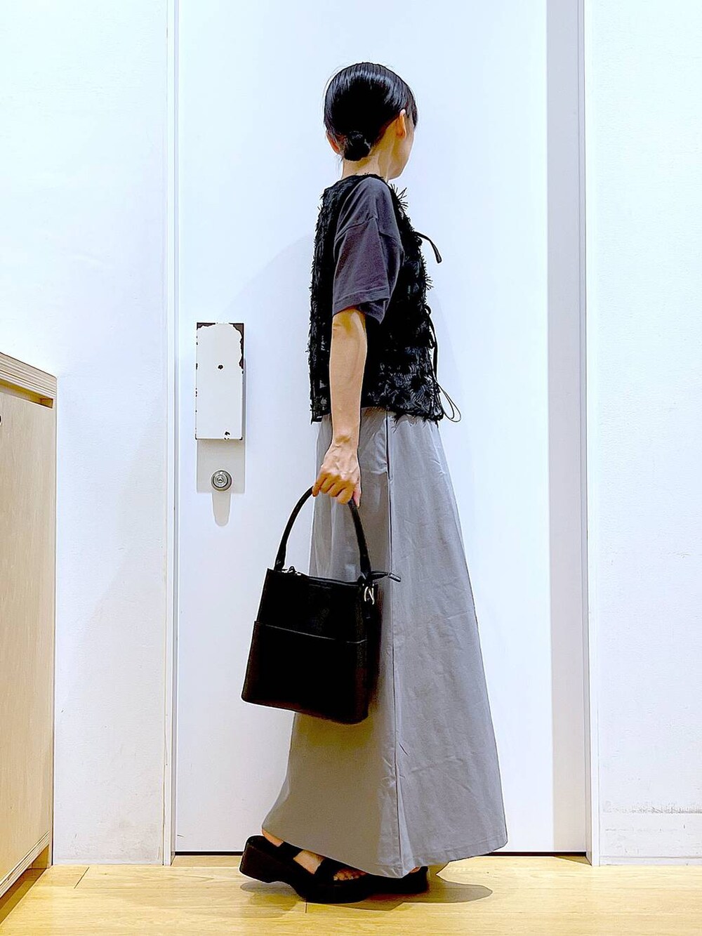 ブラック系のサンダル、ブラック系のショルダーバッグ、グレー系のスカートを着用したレディースの秋コーディネートの4枚目の写真